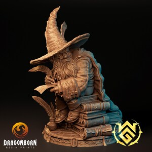 May include: A detailed resin figurine of a seated wizard, wearing a tall hat with a feather, round glasses, and a long beard. The wizard is holding quills and sitting on a stack of books. The figurine is brown with intricate details.