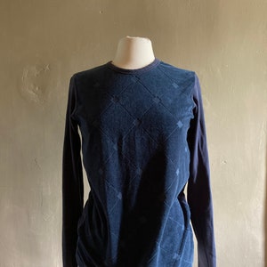 May include: A navy blue long-sleeved shirt with a diamond pattern.