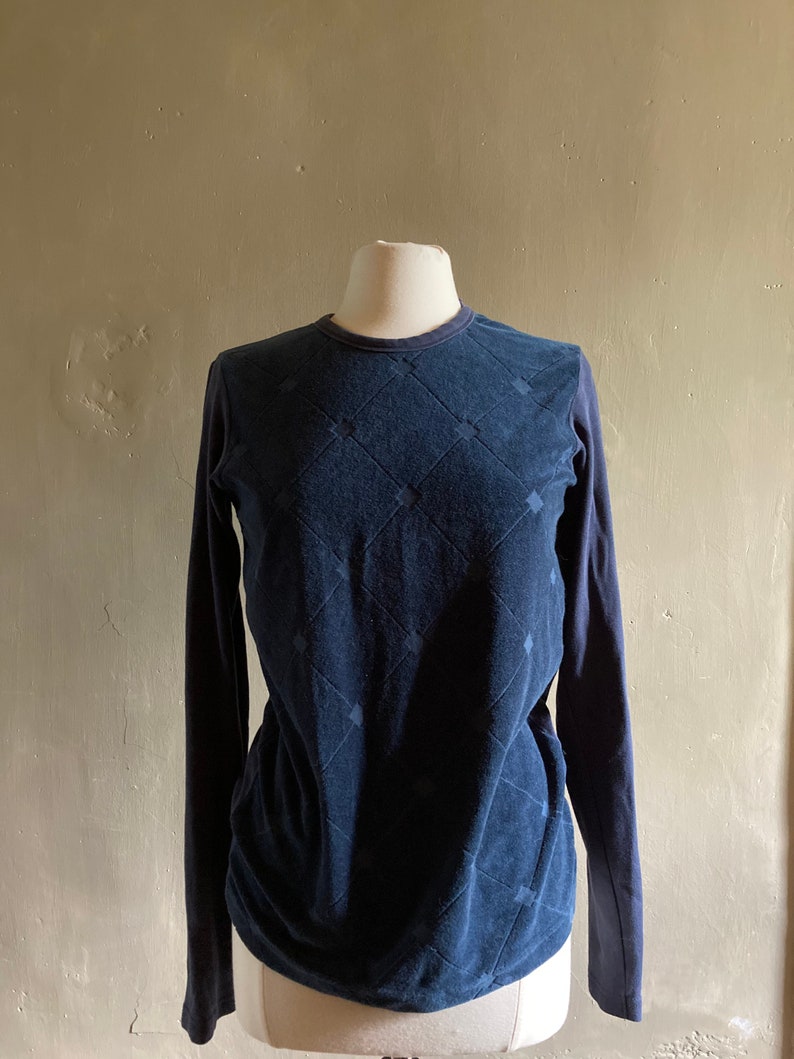 May include: A navy blue long-sleeved shirt with a diamond pattern.