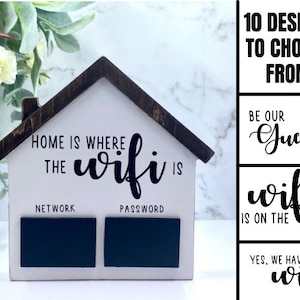 May include: White wooden house shaped sign with black text that reads "Home is where the wifi is". The sign has two black chalkboard areas labeled "Network" and "Password".