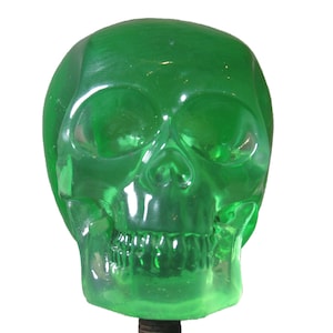 May include: A green glass skull shaped shift knob for a car.