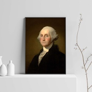 May include: A framed portrait of George Washington, the first president of the United States. The portrait is painted in a realistic style and shows Washington in a dark suit with a white cravat. He has a serious expression on his face and his white hair is styled in a powdered wig.