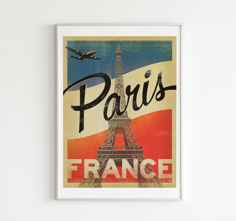 Op de afbeelding: Vintage reisposter met de Eiffeltoren in Parijs, Frankrijk. De poster heeft een rood-wit-blauw kleurenschema en bevat de tekst "Paris" en "France".