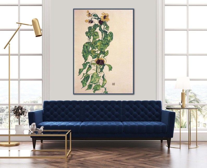 May include: A painting of a sunflower plant with yellow flowers and green leaves on a light beige background. The painting is framed in a black frame and is hanging on a white wall.
