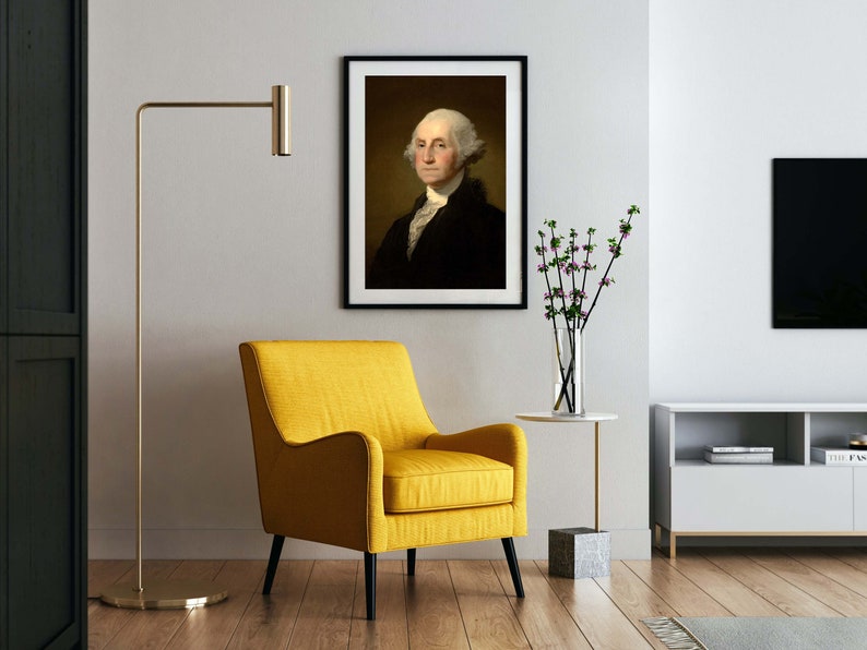 May include: A yellow armchair with black legs sits in a living room with a framed portrait of George Washington, a vase of flowers, and a television on a white cabinet.