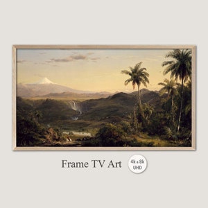 May include: A painting depicting a lush tropical landscape with a waterfall cascading down a mountainside. The scene is dominated by a large, snow-capped volcano in the distance, with palm trees and other foliage in the foreground. The painting is framed in a light wood frame.