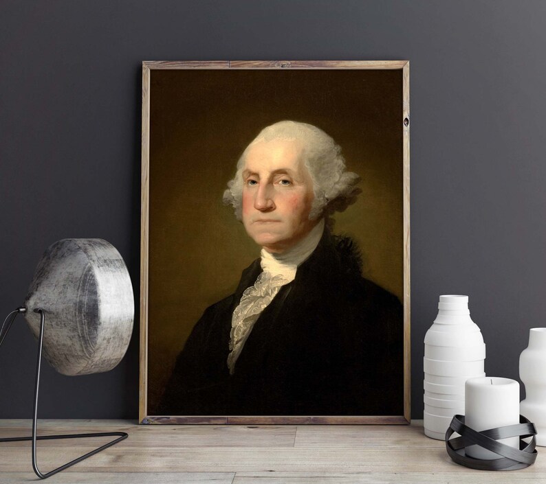 May include: A portrait painting of George Washington, the first president of the United States. He is wearing a black coat with a white cravat and has a powdered wig. The painting is framed in a wooden frame.