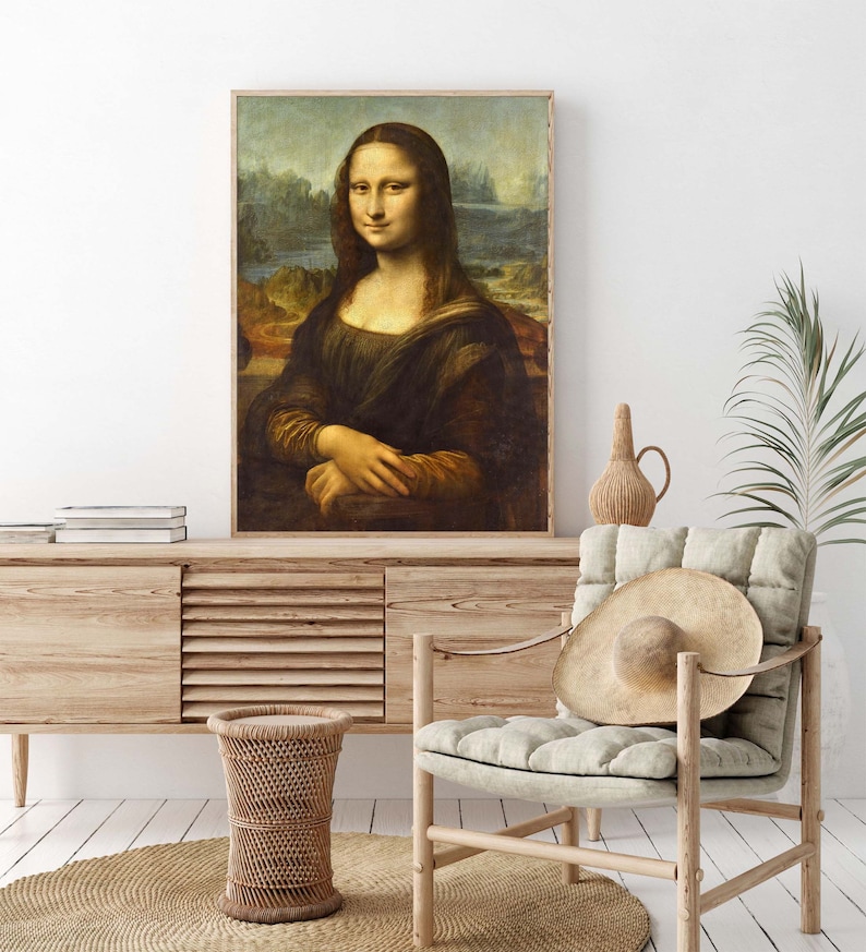 May include: A framed reproduction of the famous Mona Lisa painting by Leonardo da Vinci. The painting depicts a woman with a subtle smile, wearing a dark dress and a light background.