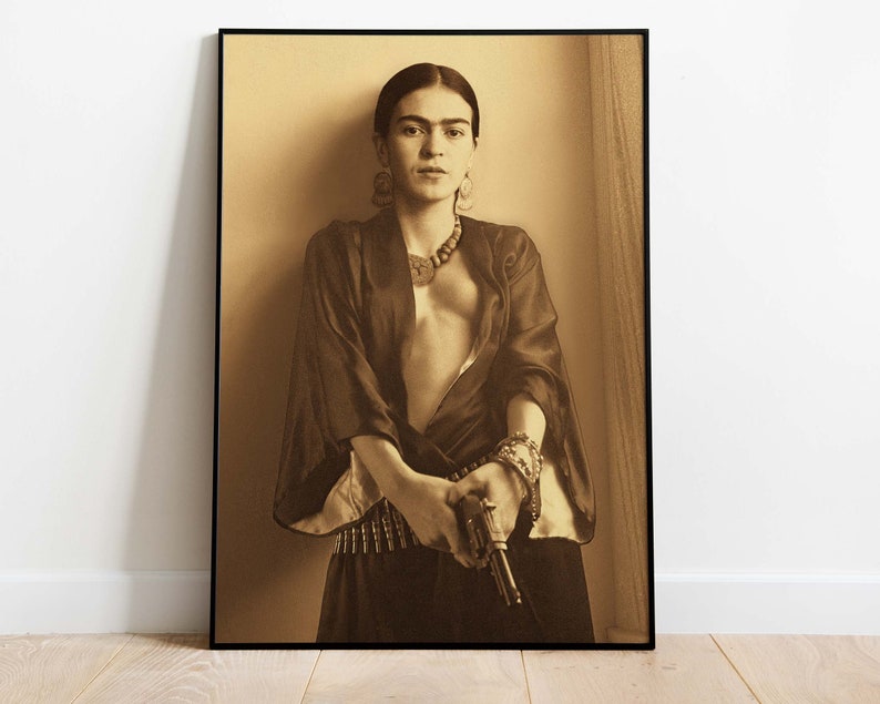 May include: A black and white portrait of a woman with dark hair, wearing a dark robe and a necklace. She is holding a gun in her right hand.