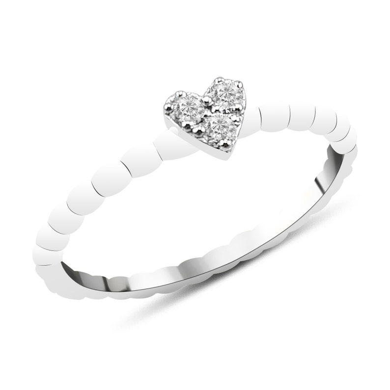 May include: A silver ring featuring a heart-shaped design with small diamonds.