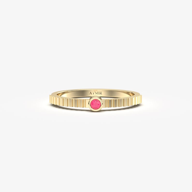 14K solid gold round ruby bezel ring, July birthstone solitaire on fluted textured band, on white background