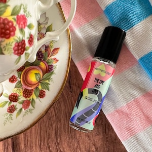 Puede incluir: Un pequeño frasco de vidrio de aceite de perfume roll-on con una etiqueta colorida que dice "Pretty Witch Craft, The One and Only, Sea Salt Jesamine, 10ml Perfume Oil".