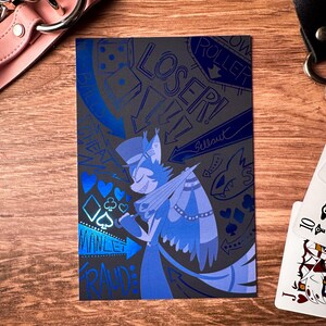 Pode incluir: Uma ilustra&ccedil;&atilde;o azul e preta de um personagem de desenho animado com um chap&eacute;u de cartola e asas. O personagem est&aacute; rodeado por s&iacute;mbolos de cartas de jogar e as palavras "Loser!" e "Manlet Fraud".