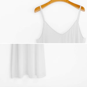 May include: A white sleeveless top with a V-neckline. The top is made of a soft, lightweight fabric and has a relaxed fit.