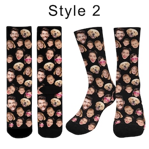 May include: A pair of black crew socks featuring a repeating pattern of various human faces and a golden retriever dog face. The text "Style 2" is printed in black at the top center of the image above the socks.