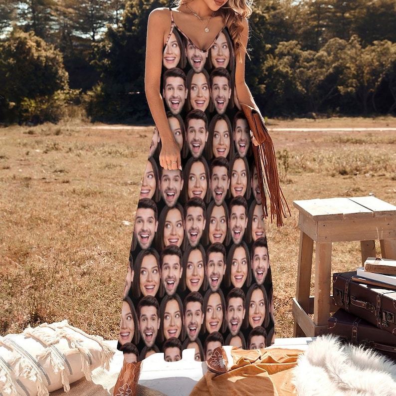 May include: A long, black maxi dress with a unique pattern of repeating faces. The dress has a V-neckline and thin straps.
