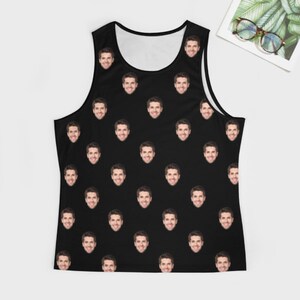 May include: A black tank top with a repeating pattern of a man's face.