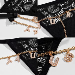 May include: Black lace lingerie with a gold chain and charms that spell out "FAUSTUS".