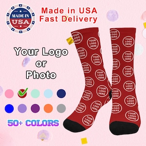 May include: Two red socks with a white circle pattern that says "Your Logo Here" on each sock. The socks are on a pink background with confetti. The text "Made in USA Fast Delivery" is at the top of the image. The text "Your Logo or Photo" is in the middle of the image. There is a checkmark next to a row of colored circles and the text "50+ COLORS" at the bottom of the image.