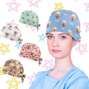 Könnte beinhalten: Eine Sammlung von Operationshauben mit Mustern. Designs umfassen eine hellblaue Kappe mit Golden Retriever-Gesichtern und dem Namen "Bailly", eine weiße Kappe mit Golden Retriever-Gesichtern und dem Namen "Bailly", eine hellgrüne Kappe mit Golden Retriever-Gesichtern, eine rosa Kappe mit Golden Retriever-Gesichtern und Herzen sowie eine Kappe mit Golden Retriever-Gesichtern.