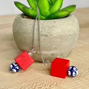Modern adjustable length drop earrings with red cube and painted ceramic bead