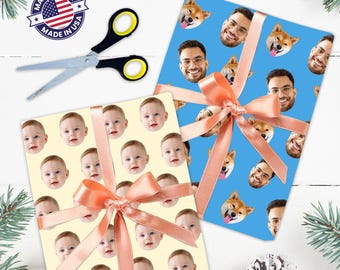 May include: Two gift wrapped boxes with a pink ribbon. One box has a pattern of baby faces on a cream background. The other box has a pattern of faces and dogs on a blue background. The text "MADE IN USA" is on a red, white, and blue star sticker.