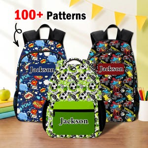 May include: Three backpacks with black straps and side mesh pockets. The left backpack has a blue comic book pattern, the center one has a white and green soccer ball pattern, and the right one has a monster truck pattern. Each features the name Jackson.