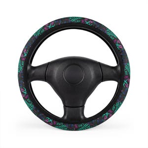 Può includere: Coprivolante nero con la parola "LIAR" in verde acqua, rosa e bianco, ripetuta attorno al bordo. Questa copertura è progettata per adattarsi a un volante standard e aggiunge un design vibrante e accattivante agli interni di un'auto.