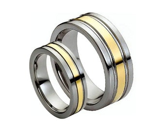 May include: A pair of wedding bands with a brushed silver finish and a gold inlay. The bands are stacked on top of each other.