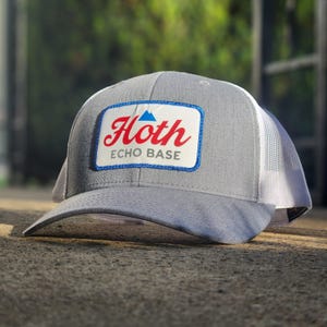 May include: A gray and white trucker hat with a blue and red patch that says "Hoth Echo Base".