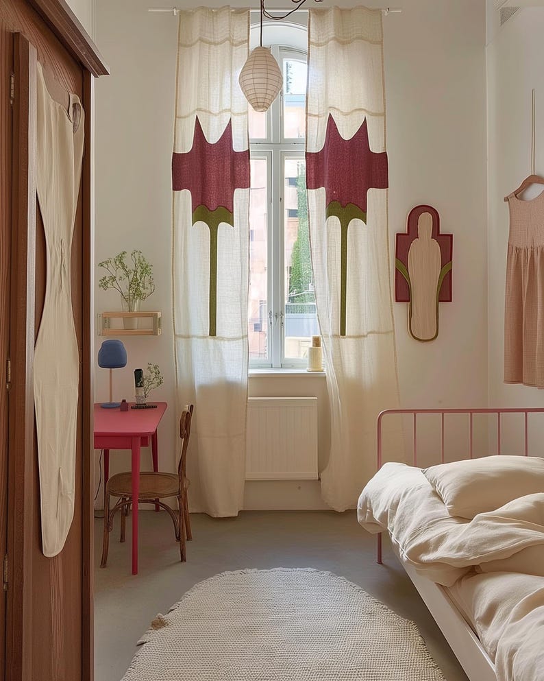 K&ouml;nnte beinhalten: Ein Schlafzimmer mit cremefarbenen Vorh&auml;ngen mit gro&szlig;en kastanienbraunen und gr&uuml;nen Blumenmotiven, einem rosa Schreibtisch mit Holzstuhl, einem rosa Metallbett mit cremefarbener Bettw&auml;sche, einem ovalen cremefarbenen Teppich und einem Holzschrank.