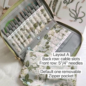 K&ouml;nnte beinhalten: Ein Stoffetui mit Rei&szlig;verschluss und Blumenmuster enth&auml;lt Metallstricknadeln in beschrifteten F&auml;chern von 2mm bis 5mm. Das Etui enth&auml;lt eine herausnehmbare Rei&szlig;verschlusstasche und den Text: Layout A, Back row: cable slots, Front row: 5"/4" needles, Default one removable Zipper pocket.