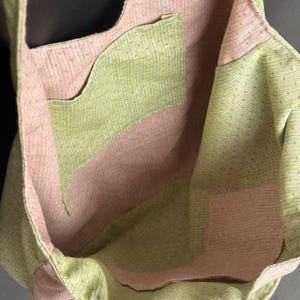 Pu&ograve; includere: Borsa tote fatta a mano con un design patchwork. La borsa presenta una combinazione di colori verde chiaro e rosa. La tasca interna &egrave; verde chiaro. La borsa &egrave; in tessuto e ha una tracolla.