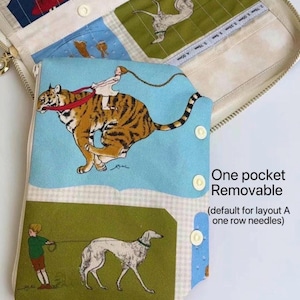 Peut inclure: Un étui à aiguilles en tissu avec une pochette amovible illustrée d'une personne chevauchant un tigre et d'une personne promenant un chien. L'étui présente des bordures crème, des boutons-pression blancs et le texte One pocket Removable (default for layout A one row needles).