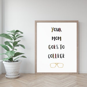 May include: A framed print with the text "YOUR MOM GOES TO COLLEGE" in black and white with colorful accents. The text is in a playful, hand-drawn style. A pair of gold-rimmed glasses are below the text.