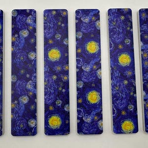 May include: Six rectangular bookmarks featuring a print of Van Gogh's "Starry Night" painting. The design includes swirling blue brushstrokes, yellow stars, and a large yellow moon. The bookmarks are arranged side by side.