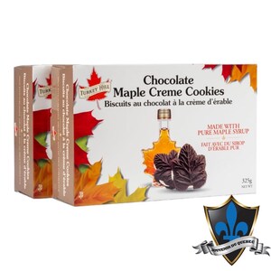 May include: Two boxes of Turkey Hill Chocolate Maple Creme Cookies. The boxes are white with red maple leaves and a picture of a bottle of maple syrup. The text on the box reads "Chocolate Maple Creme Cookies" and "Biscuits au chocolat à la crème d'érable". The boxes are 325g (11.5 oz) each.
