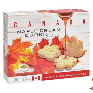 May include: A box of Canada True Maple Cream Cookies, featuring a red and orange maple leaf design. The box is 12.3 oz (350g) and states that the cookies are made with pure Canadian maple syrup.