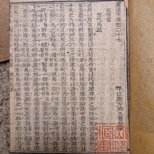 May include: A close-up of a page from an old book with text in Japanese. The page is yellowed with age and has a red stamp that says "Secret Documents".