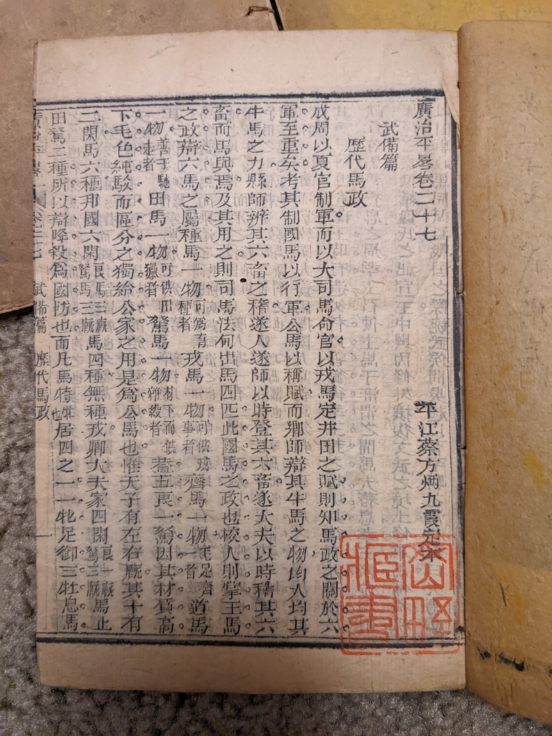 May include: A close-up of a page from an old book with text in Japanese. The page is yellowed with age and has a red stamp that says "Secret Documents".