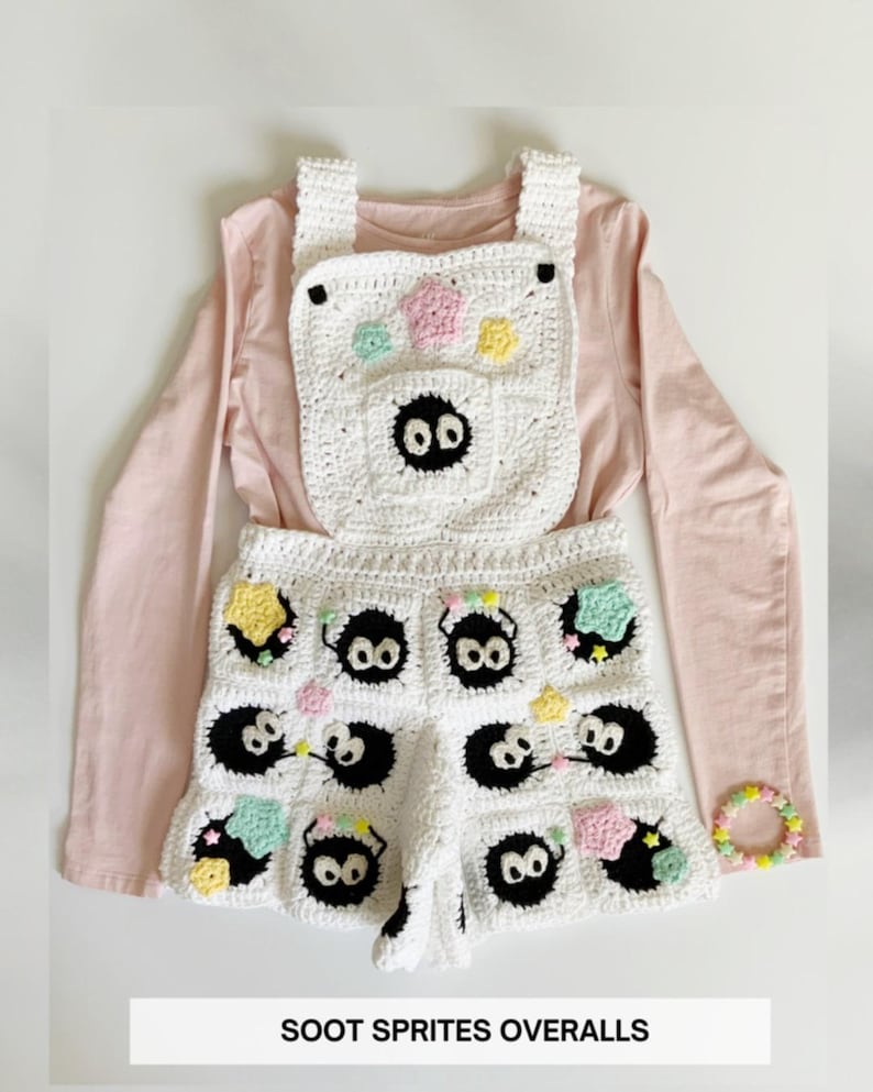 Puede incluir: Mono blanco de ganchillo con dise&ntilde;os negros de Soot Sprite, detalles de estrellas y flores de colores, y una pulsera a juego. El mono se combina con una camiseta de manga larga rosa claro. El texto en la imagen dice "SOOT SPRITES OVERALLS."