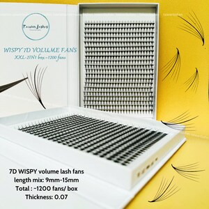 May include: A white box with a clear lid containing 7D wispy volume lash fans. The box is labelled "WISPY 7D VOLUME FANS XXL-21N1 box-1200 fans". The lash fans are arranged in rows and columns. The box is sitting on a yellow surface. The lash fans are 9mm-15mm in length and have a thickness of 0.07. There are approximately 1200 fans per box.