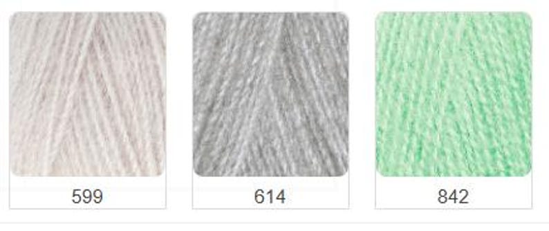 Puede incluir: Tres madejas de hilo en fila, cada una en un marco cuadrado. Los colores del hilo son blanco roto (599), gris (614) y verde claro (842). Cada marco tiene un n&uacute;mero en la parte inferior.