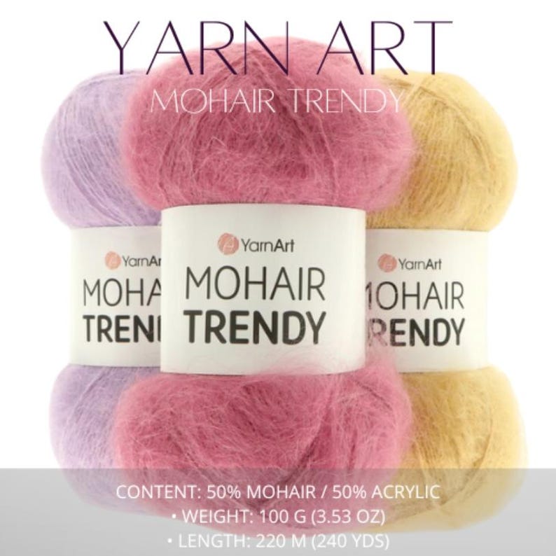 May include: Image of Yarn Art Mohair Trendy yarn in pink, lavender, and yellow. The fluffy yarn balls have labels with the brand name and product details. The label states the yarn is 100g. The text on the image reads: Mohair Trendy.