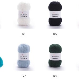 May include: Eight balls of YarnArt Mohair Trendy yarn in a range of colours. Shades include white, black, red, teal, light blue, dark green, and burgundy. Each ball has a label displaying the brand name and a colour number.