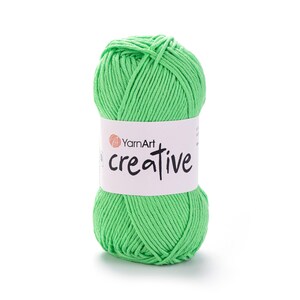 May include: A ball of bright green YarnArt Creative yarn. The yarn is wrapped around itself, with a white label that reads "YarnArt creative" in black script. The yarn is a vibrant, solid colour, perfect for knitting and crochet projects.