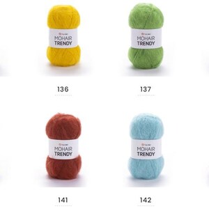 May include: Eight balls of mohair yarn in various colours: beige, yellow, green, purple, blue, red, light blue, and pink. Each ball has a white label with "MOHAIR TRENDY" and a number below.