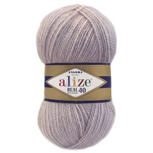 Puede incluir: Una madeja de hilo Alize Real 40 en un suave color lavanda apagado. El hilo est&aacute; etiquetado con el nombre de la marca, "Alize", y el nombre del producto, "Real 40". La etiqueta tambi&eacute;n incluye la palabra "Angora". Este hilo se utiliza probablemente para proyectos de punto y ganchillo.