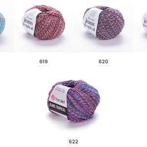 Op de afbeelding: Vijf bollen garen in verschillende kleuren, met het label "Jeans Tropical" en de nummers 618, 619, 620, 621 en 622. De garenkleuren zijn onder meer blauw, paars, roze en blauwgroen. Het garen is waarschijnlijk voor brei- of haakprojecten.