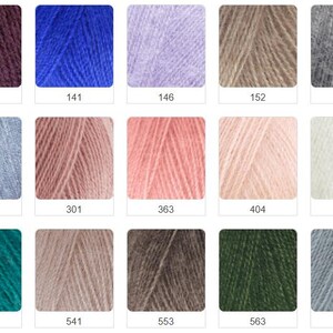 Puede incluir: Una colecci&oacute;n de madejas de hilo en varios colores, incluyendo tonos de morado, azul, rosa y verde. Cada madeja est&aacute; etiquetada con un n&uacute;mero, como 111, 141 y 146. El hilo parece suave y esponjoso, ideal para proyectos de tejido o ganchillo.